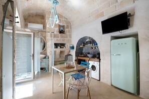 Una cocina compacta con lavadora, microondas y refrigerador pequeño.