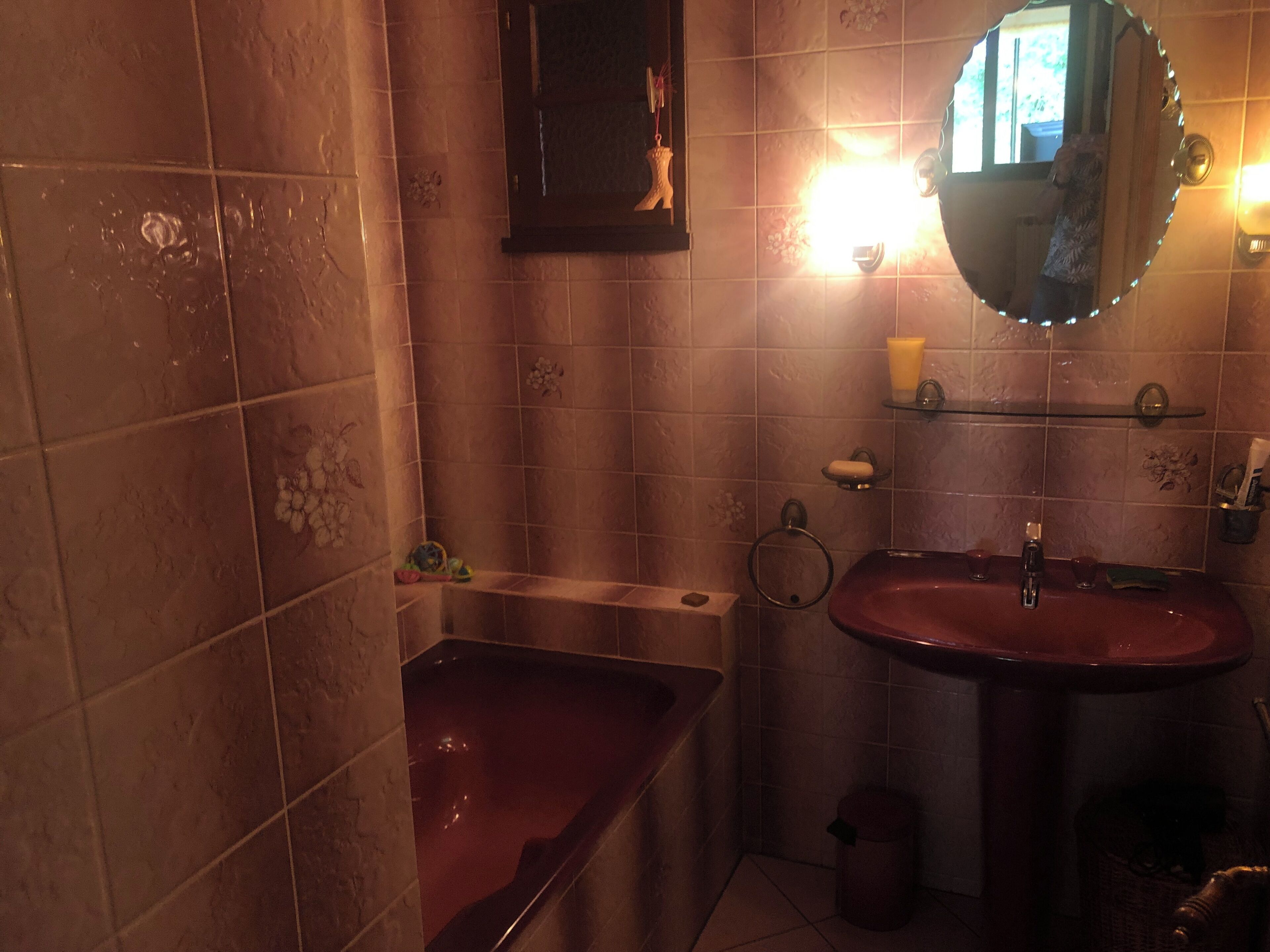 A bathroom with a bathtub, sink, and mirror.