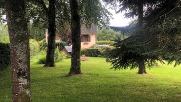 A grassy area with trees and a building in the background.