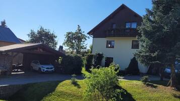 Ein zweigeschossiges Haus mit einer überdachten Auffahrt und einem kleinen Rasen.