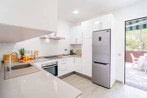 A modern kitchen with white cabinetry, stainless steel appliances, and a wooden countertop. - Cubo's Afrodita House / urban / terrace / air conditioning / free wifi (Alhaurín el Grande)