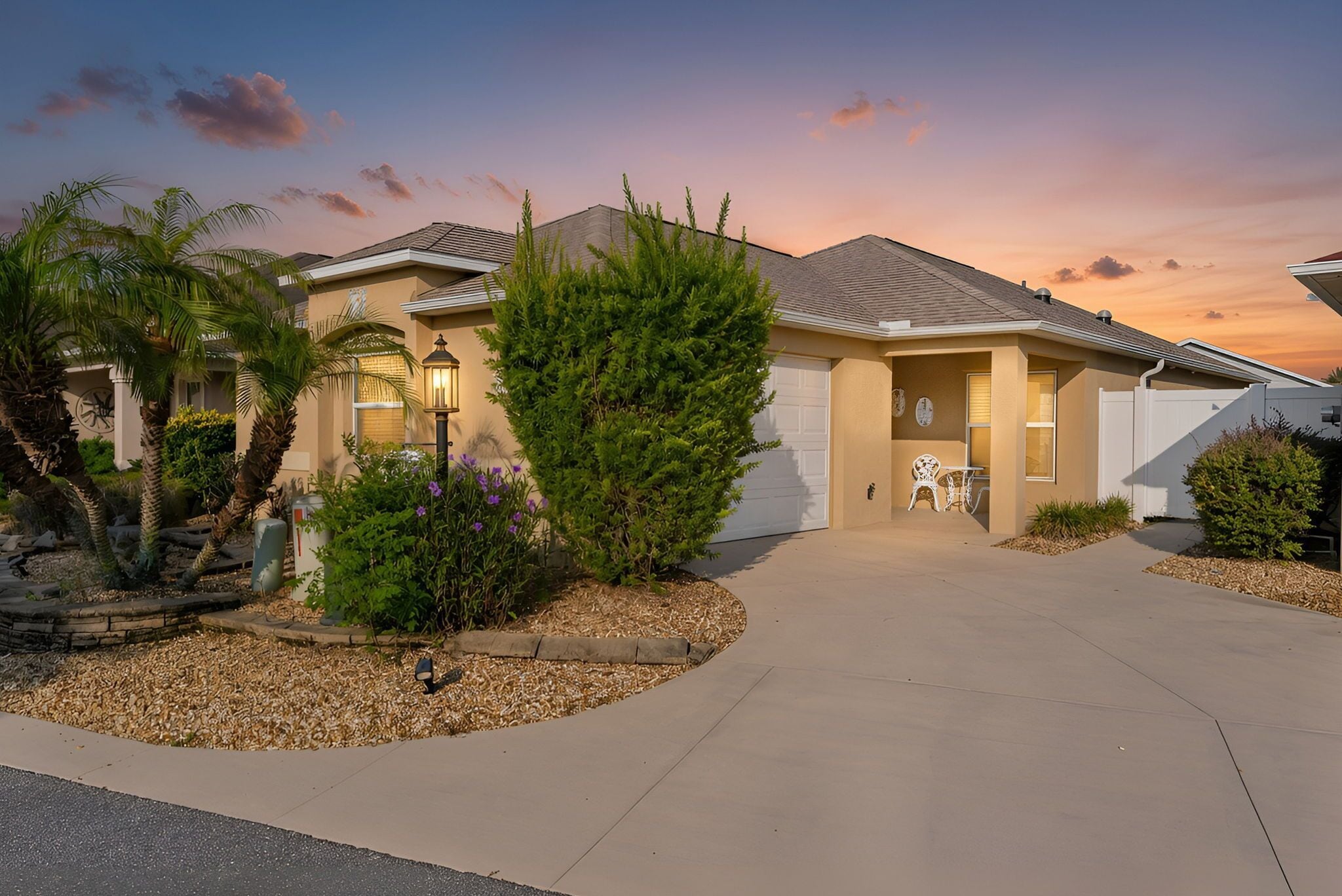 A residential house with a driveway, a lawn, and a patio area.