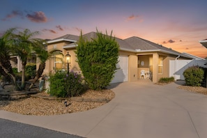 A residential house with a driveway, a lawn, and a patio area. - Private Courtyard Villa with All-Weather Lanai Near Brownwood (The Villages)