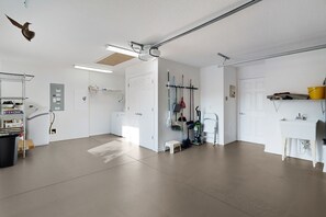 A clean, well-lit room with a large window, a white door, and a shelf with cleaning supplies. - Private Courtyard Villa with All-Weather Lanai Near Brownwood (The Villages)