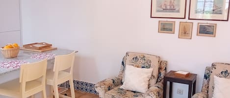 A dining area with a table, chairs, and a small rug.