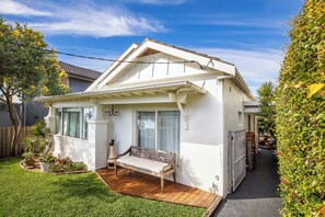 A single-story house with a covered porch, a bench, and a small garden area. - Maroubra Escape Beachside Charm and Ocean Glimpses (Maroubra)