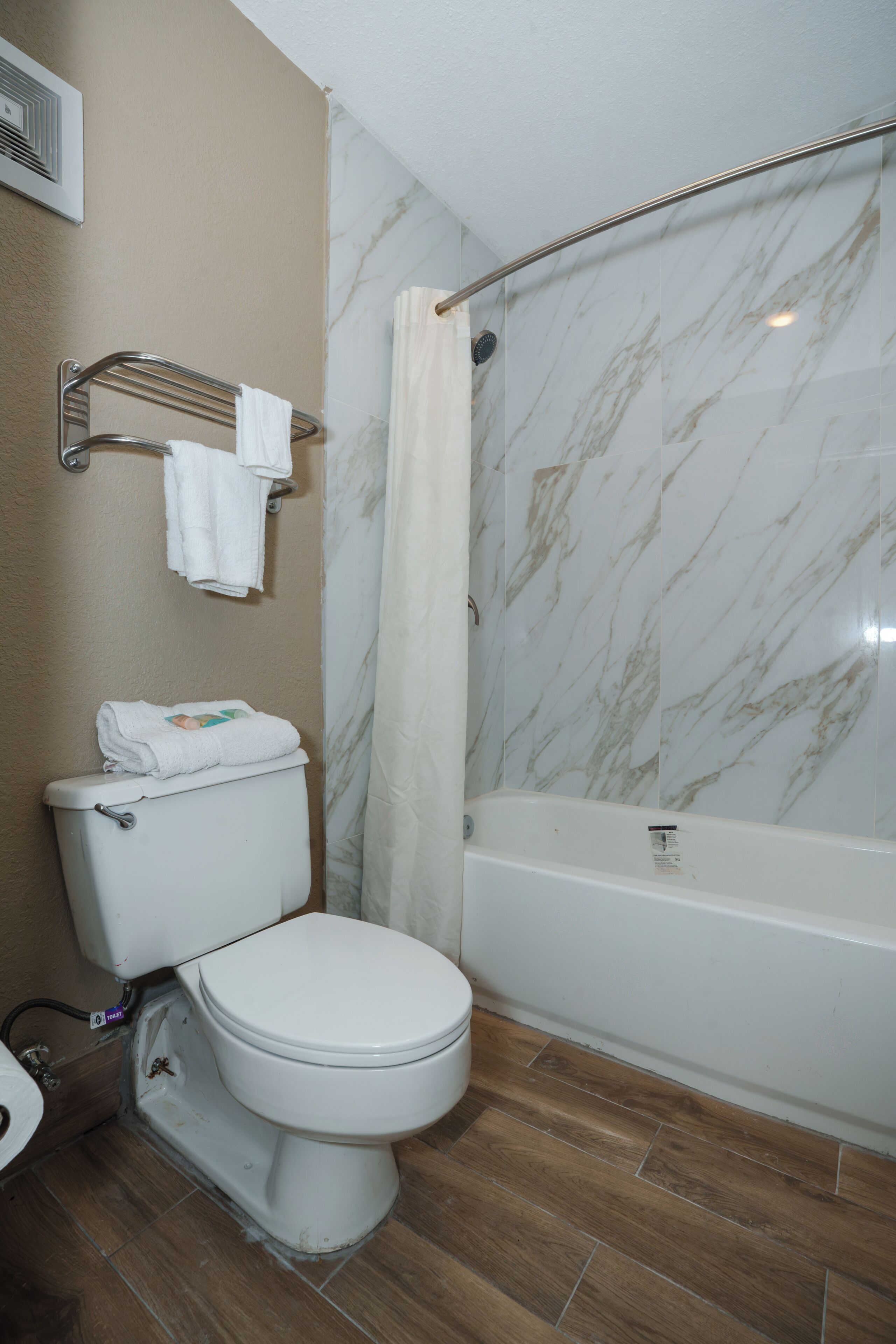 A bathroom with a toilet, a shower, and a bathtub.