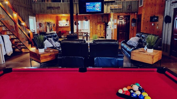 A pool table with balls, a television, and a wooden interior with leather seating. - 4-bedroom Open concept Farmhouse minutes from Norfork Lake (Clarkridge)