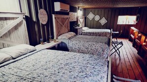 A rustic room with two beds, wooden walls, and a small table with decorative items. - 4-bedroom Open concept Farmhouse minutes from Norfork Lake (Clarkridge)