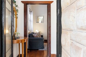A hallway leading to a bedroom with a bed, a bedside table, and a wall-mounted picture. - Glandore Charm Contemporary Haven near CBD and Coast (Glandore)
