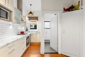 Una cocina moderna con armarios blancos, estufa y microondas.