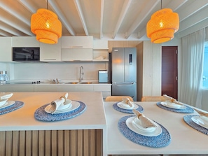 Una cucina moderna con isola centrale, elettrodomestici in acciaio inossidabile e illuminazione a sospensione.