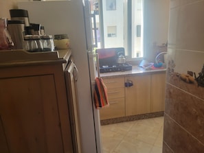 A kitchen with a gas stove, cabinets, and a window.