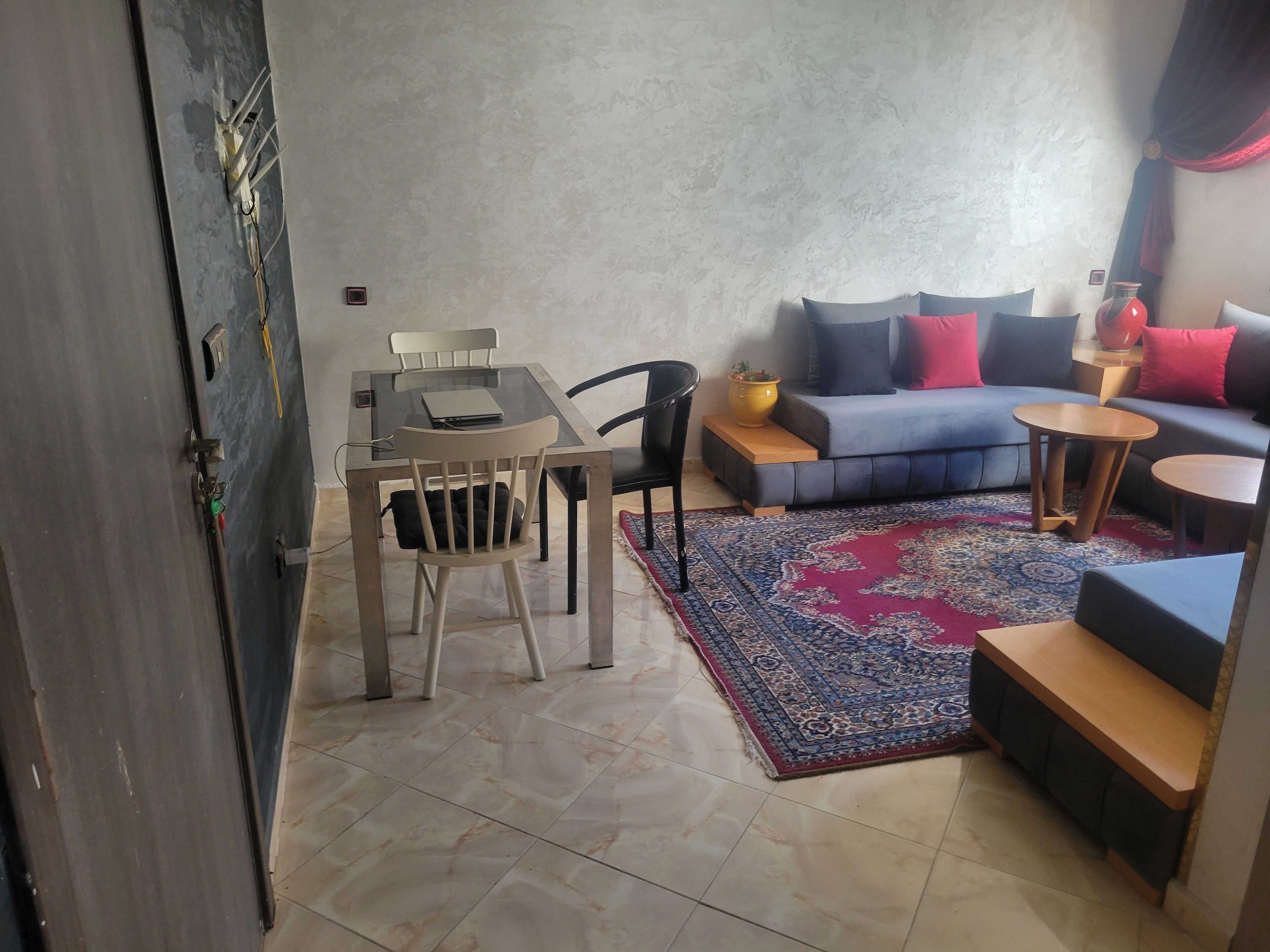 A living area with a sofa, a coffee table, a rug, and a dining table with chairs.