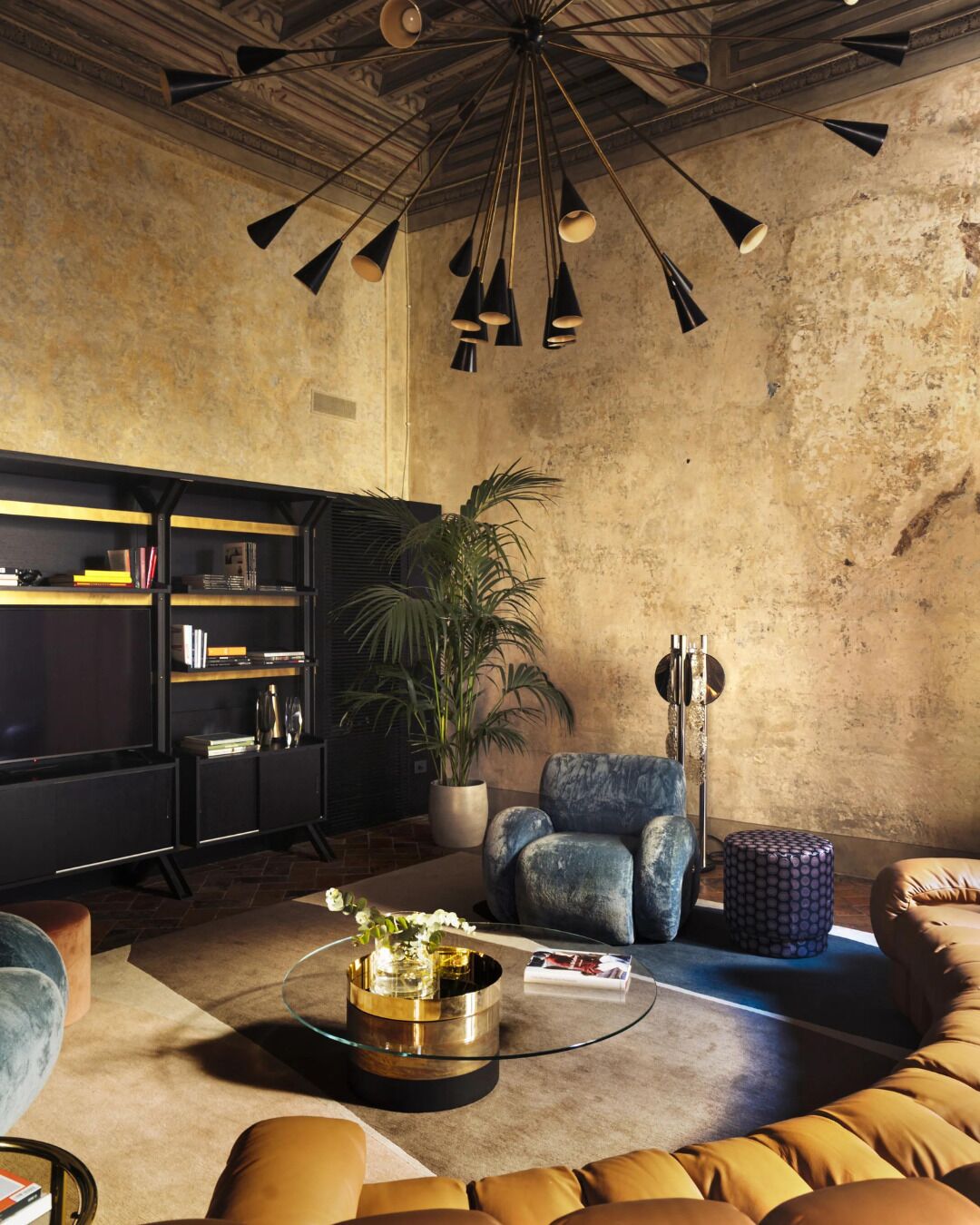 Ein Wohnzimmer mit einer Couch, einem Couchtisch, einem Bücherregal und einer Pflanze.