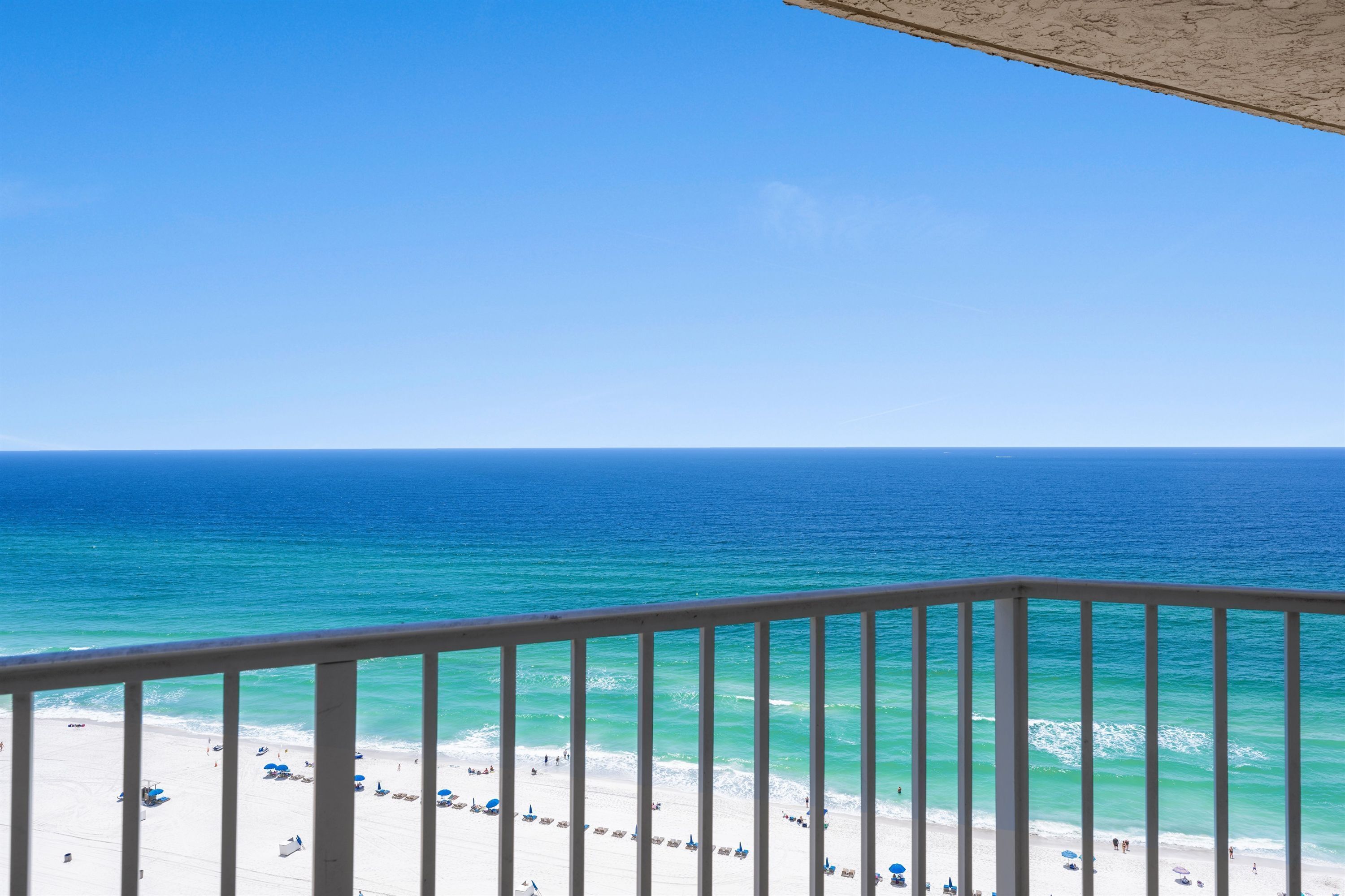 Un balcon avec vue sur une plage et l’océan.
