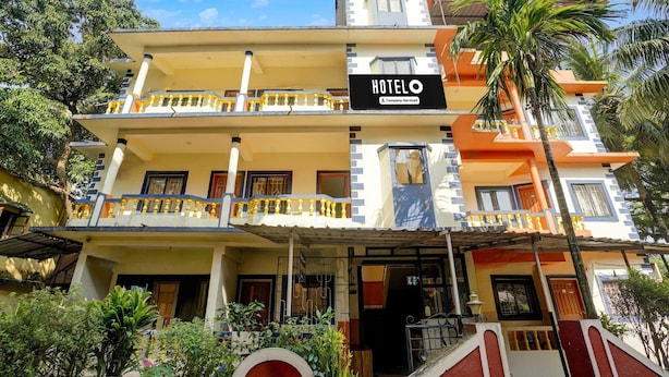 A multi-story hotel with a sign indicating it is company-serviced. - Saver Double Crystal Holiday Homes (Calangute)
