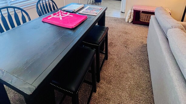 A dining area with a table, chairs, and a ceiling fan.