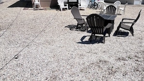 A two-story building with a patio area featuring outdoor furniture and string lights.