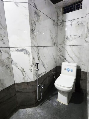 Baño con inodoro, ducha y baranda.