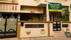 A multi-story building with a sign for 'Nityam Stay' indicating available rooms. - Hotel Nityam Stay (Ujjain)