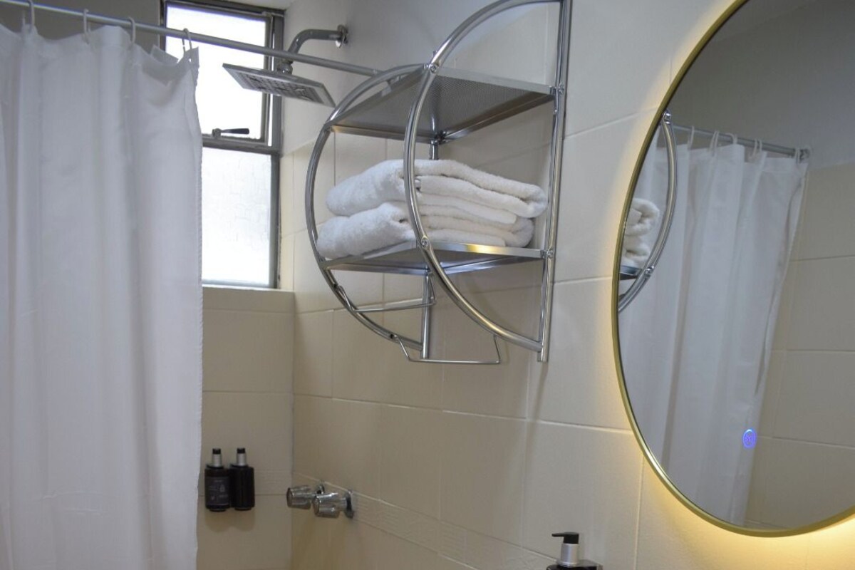 A bathroom with a toilet, bidet, sink, and a towel rack.