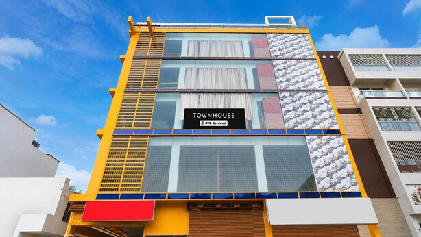 Ein mehrstöckiges Gebäude mit einem Schild, auf dem 'TOWNHOUSE' und 'OVO-Serviced' steht.