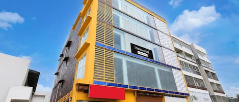 A multi-story building with a sign indicating it is a serviced apartment.