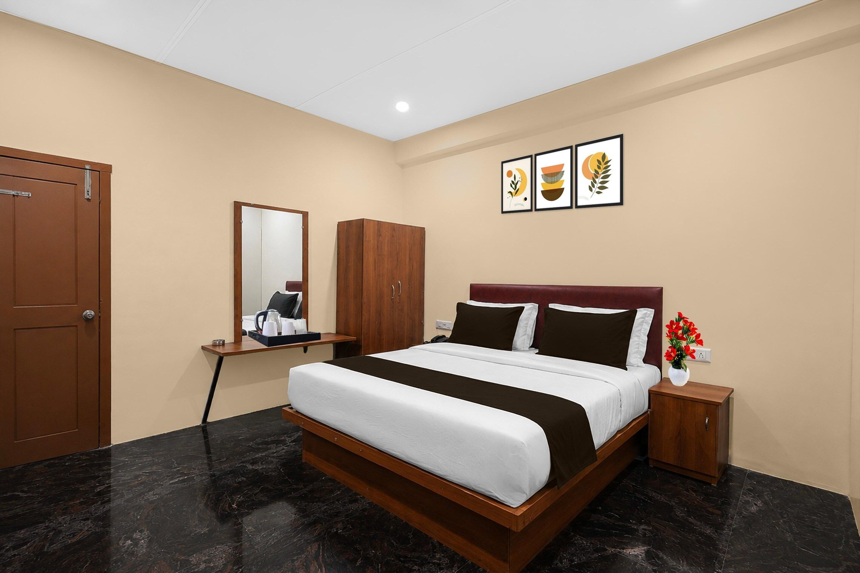 Ein Hotelzimmer mit Bett, Schreibtisch, Kleiderschrank und Nachttisch.