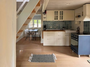 A kitchen with a dining area, wooden flooring, and a view of the outdoors. - Historic house from 1827 on Langeland (Rudkøbing)