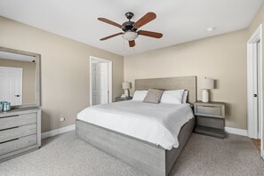A bedroom with a bed, nightstands, a ceiling fan, a dresser, and a door. - Sunlit Mountain Retreat Near Lakes & Ski Fun (Arnold)