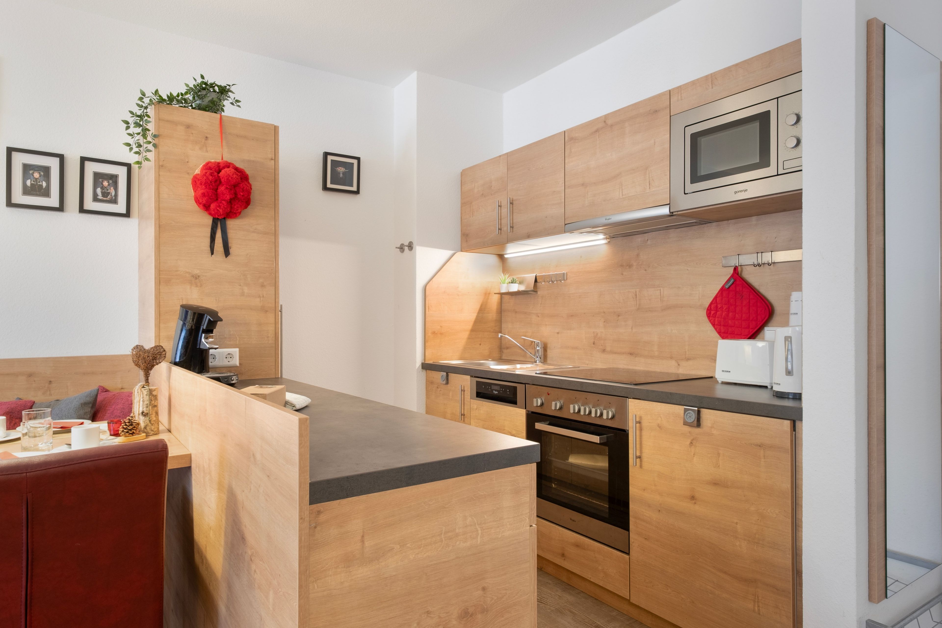Una cocina moderna con armarios de madera, horno empotrado y microondas.