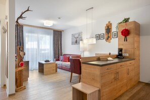 Una sala de estar moderna con un sofá, una mesa de centro y un comedor con un mueble de madera y una cafetera.