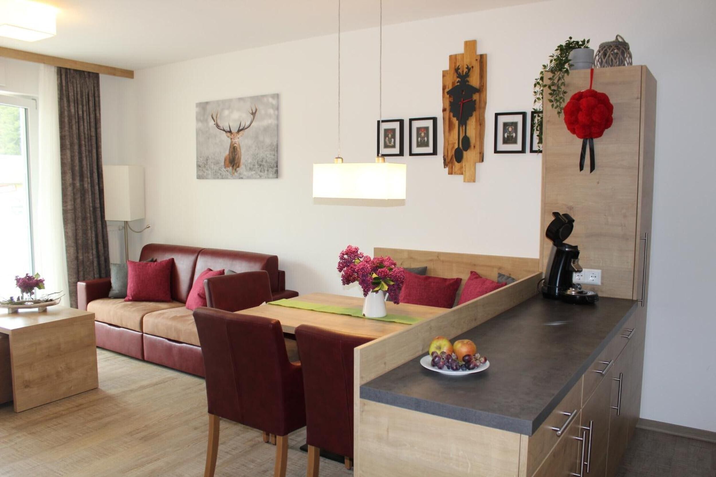 Una sala moderna con un sofá, un comedor con sillas, una cafetera y una encimera de cocina.