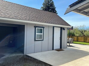 A single-story building with a garage door, a small window, and a door.