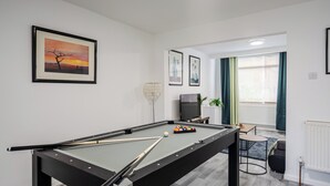 A pool table with balls and cues, a television, and framed artwork on the walls. - 3 Bedroom House - Pool Table, Opp Train Station (Manchester)