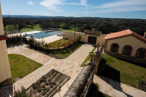 A rooftop pool area with a view of the countryside.
