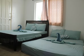 Ein Zimmer mit zwei Betten, jeweils mit Kopfteil und Kissen.