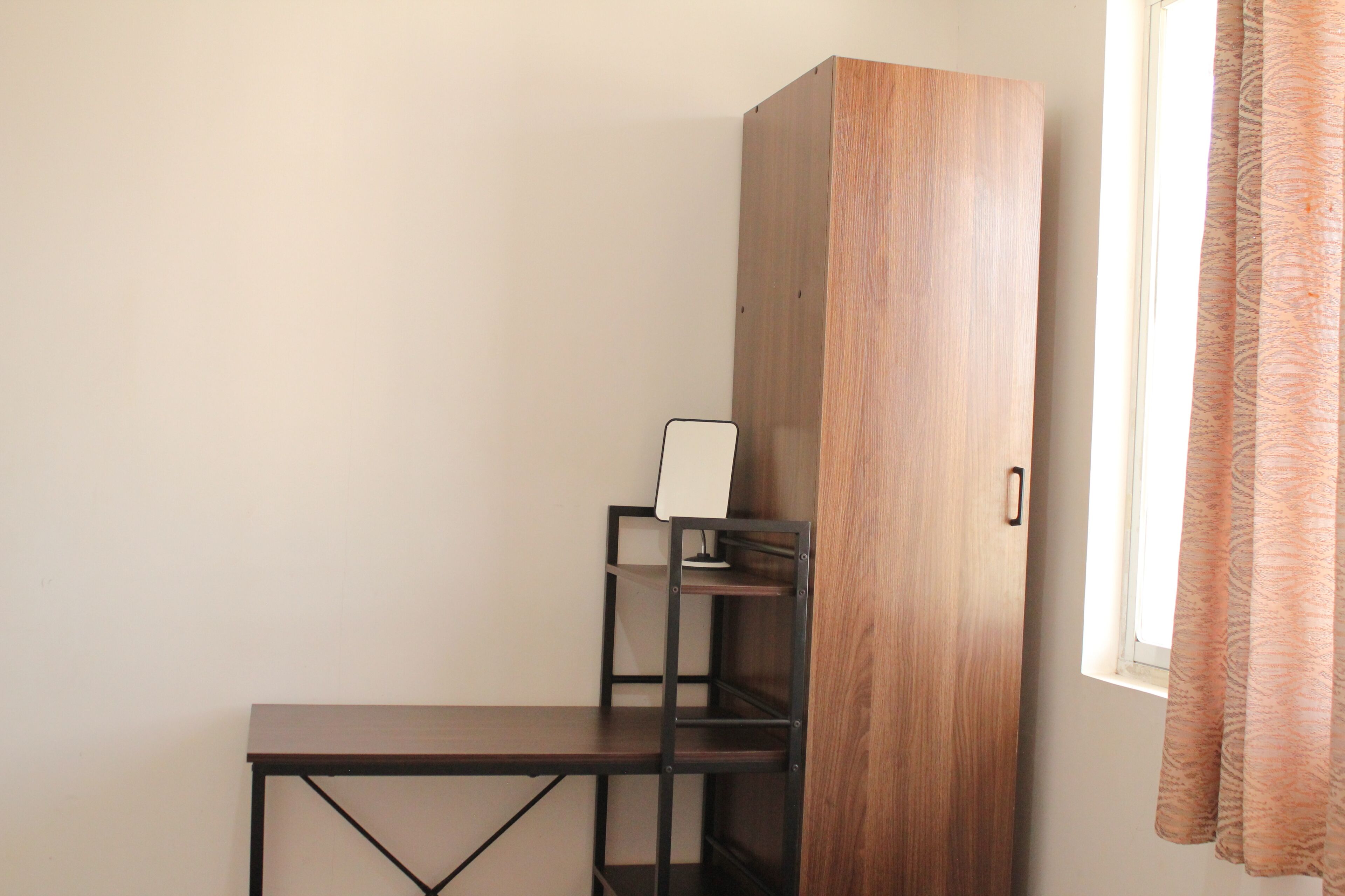Een kamer met een houten kast, een tafeltje en een plankunit.
