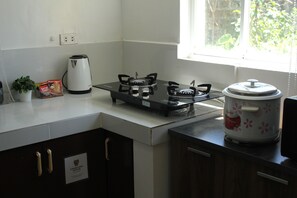 Une cuisine équipée d’une cuisinière à gaz, d’une machine à café et d’un appareil de cuisson lente.