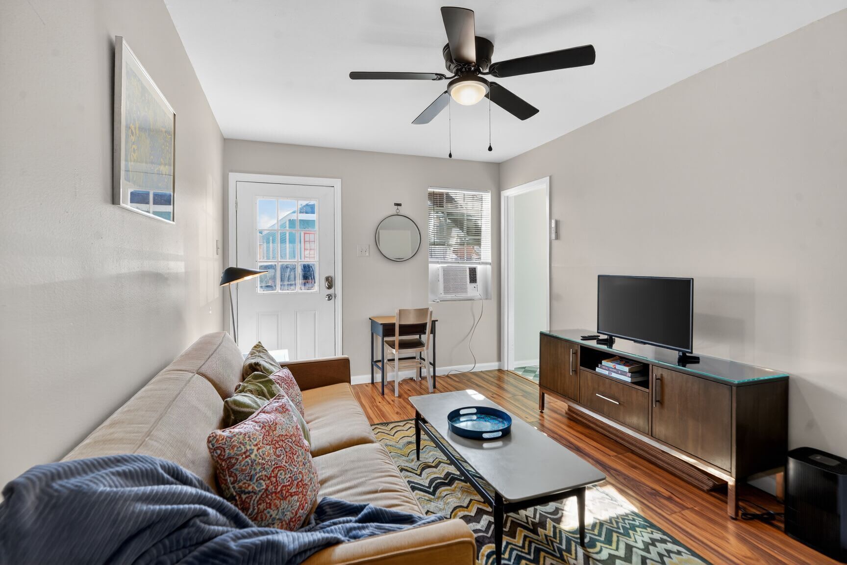 A modern living room with a sofa, coffee table, and television.