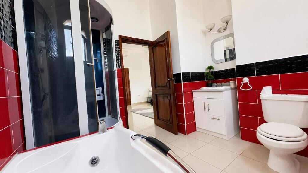 A bathroom with a white bathtub, a toilet, and a sink.
