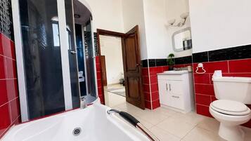 A bathroom with a white bathtub, a toilet, and a sink.