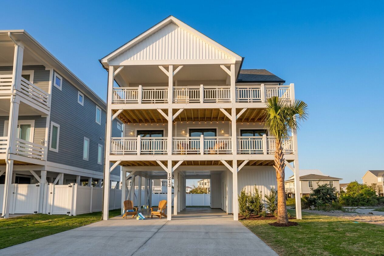 A multi-story residential building with a balcony on each floor, a covered entryway, and a palm tree in the foreground.