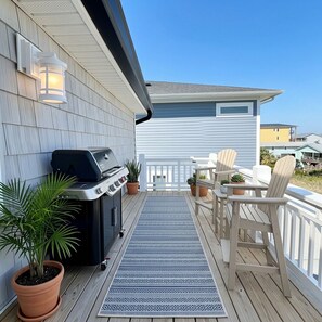 A deck with a grill, potted plants, and outdoor furniture. - Sweet SeaRenity- SURF CITY -New Luxury 4B, Ocean Views, Steps to Beach, Elevator (Surf City)