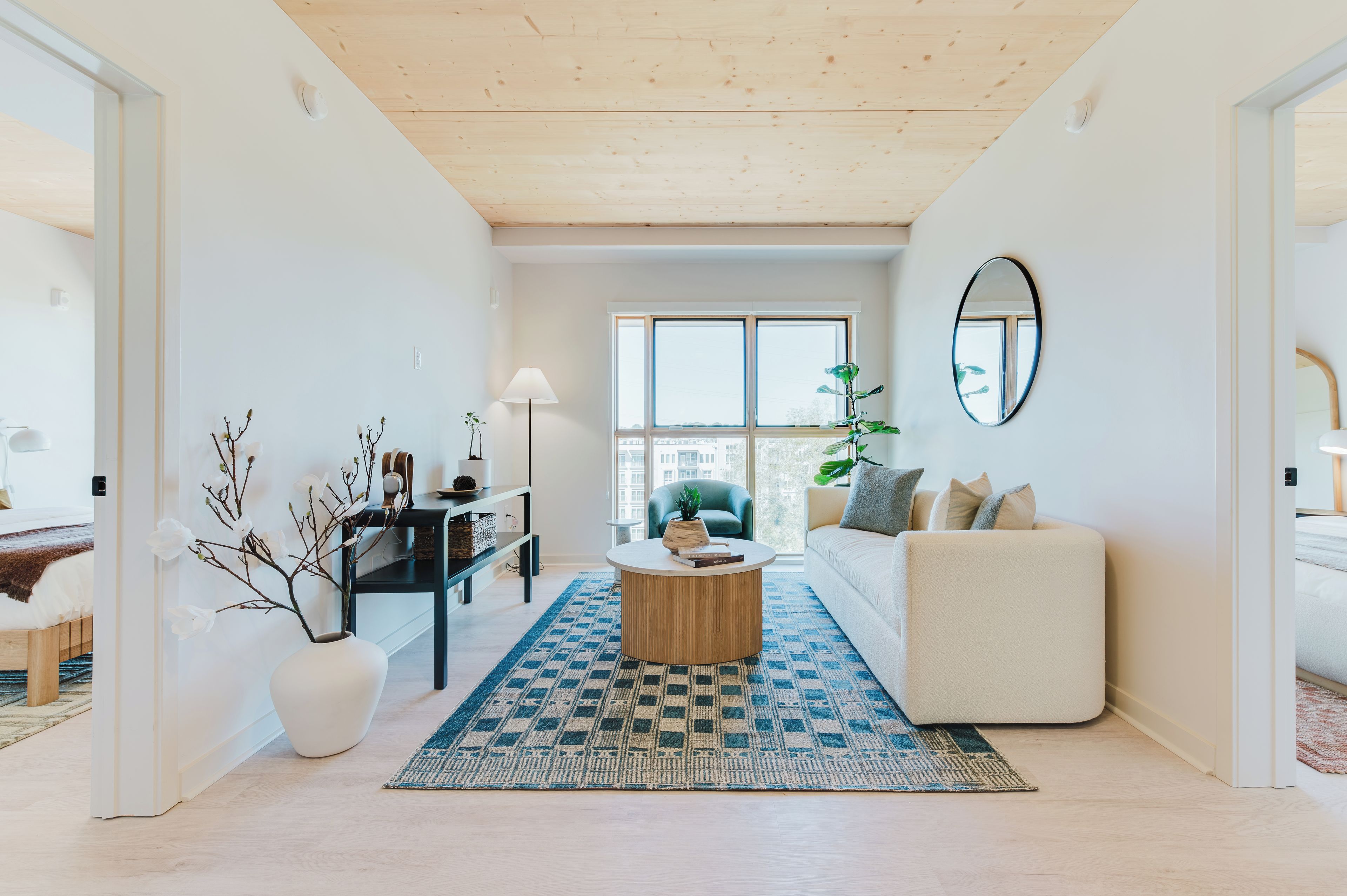 A modern living room with a sofa, coffee table, and a large window.