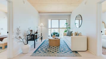 A modern living room with a sofa, coffee table, and a large window.