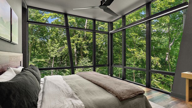 A bedroom with a large window, a bed, and a ceiling fan. - The Treehouse at Norstead (Cedar)