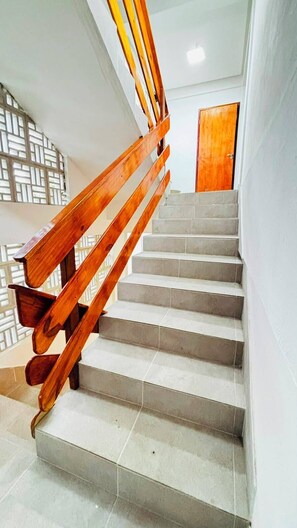 Un escalier avec des rampes en bois et des marches de couleur claire.