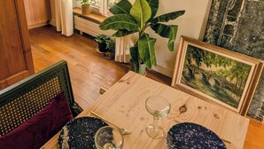 A dining table set with plates, glasses, and cutlery, surrounded by chairs and a bench. - Parisian charm, sunny apartment, beautiful views (Paris)